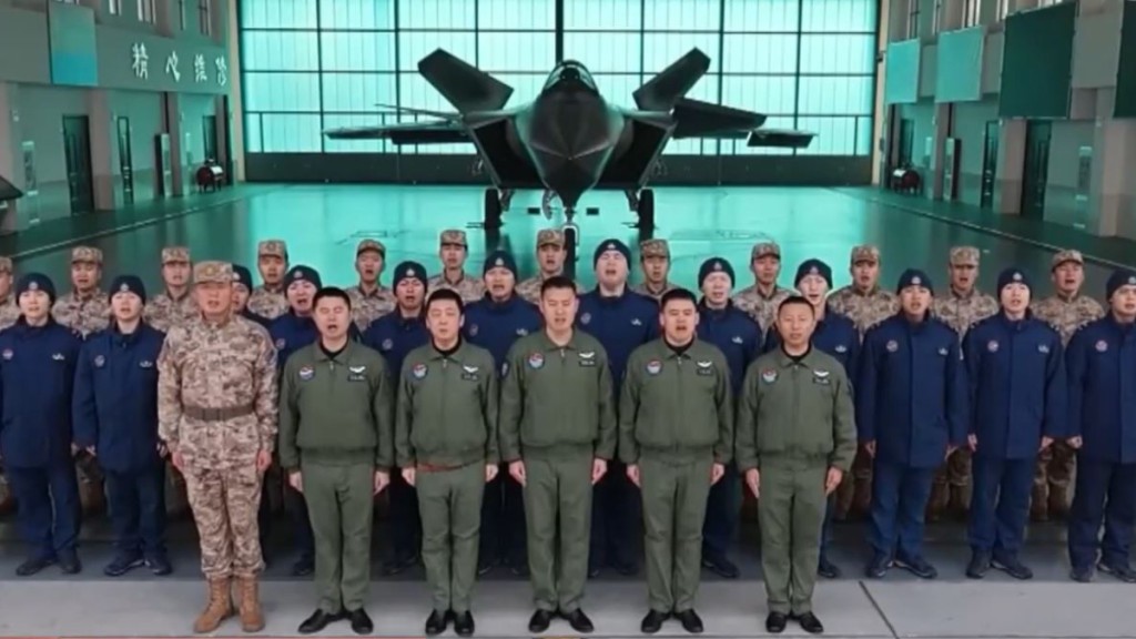 解放军多个部队站在最新装备面前向国民拜年。图为歼-20隐身战机。央视