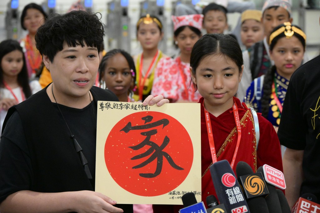 學生受惠通行證措施，故準備一份寫上「粵港一家親」五個毛筆字的禮物，感謝特首李家超。 