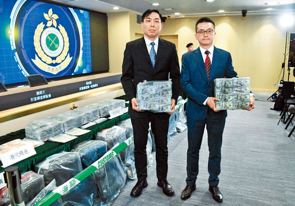 海關有組織罪案調查科財富調查課監督楊郁文（左）及財富調查第一組指揮官黃貞富，展示證物。