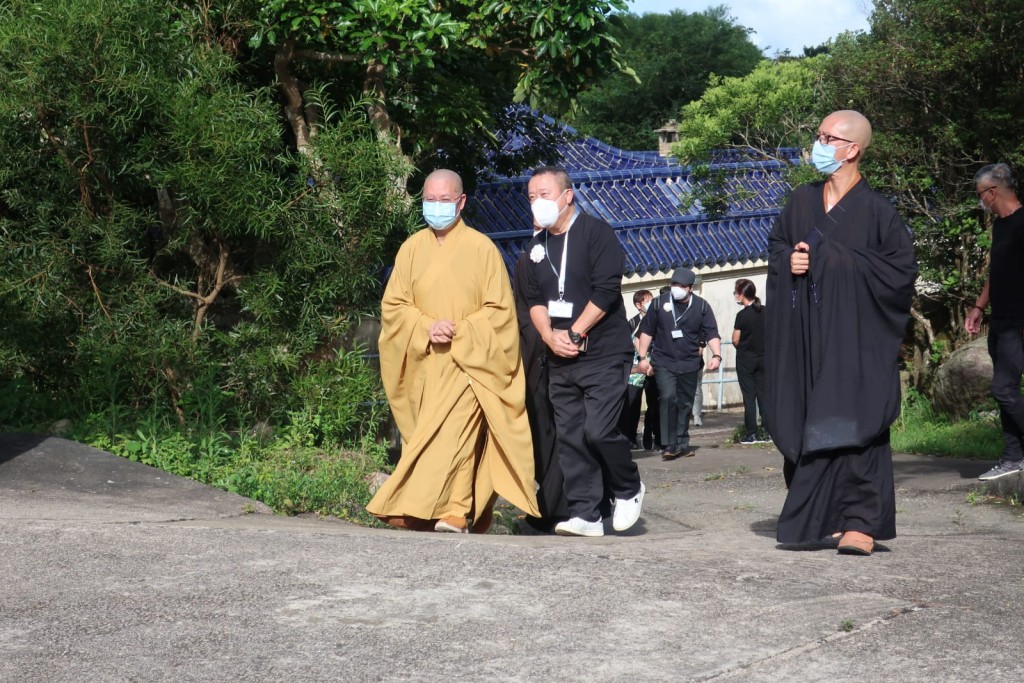 志伟与法师行前，家属在后跟随。