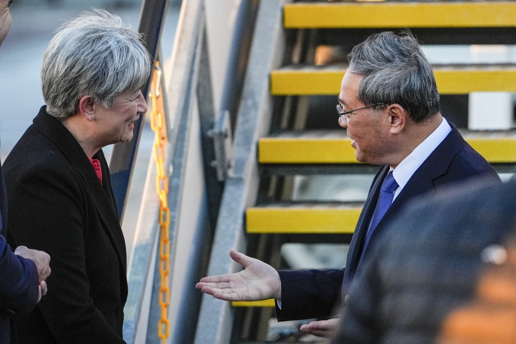 中國總理李強（右）抵達澳洲阿德萊德機場，受到澳洲外交部長黃英賢的歡迎。 AP