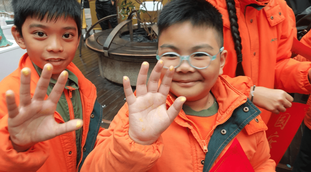 對於非本地的小學生來說，拓印揮春屬難能可貴的體驗，並開心向人前展示五指染金。