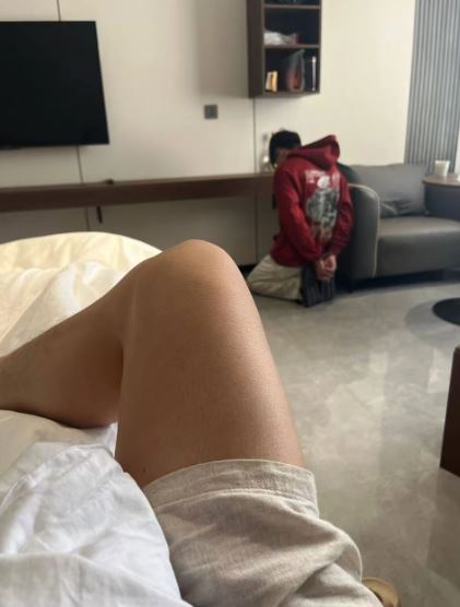 王祖校跪在地上，雙手被手銬銬著。