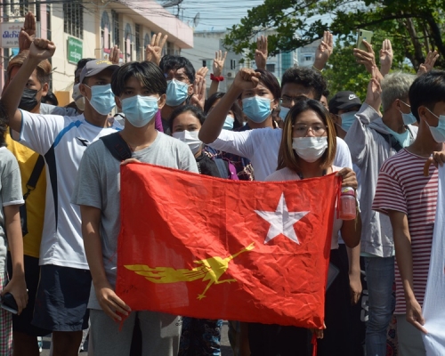 反政變抗議者高舉全國民主聯盟黨的旗幟遊行。AP  
