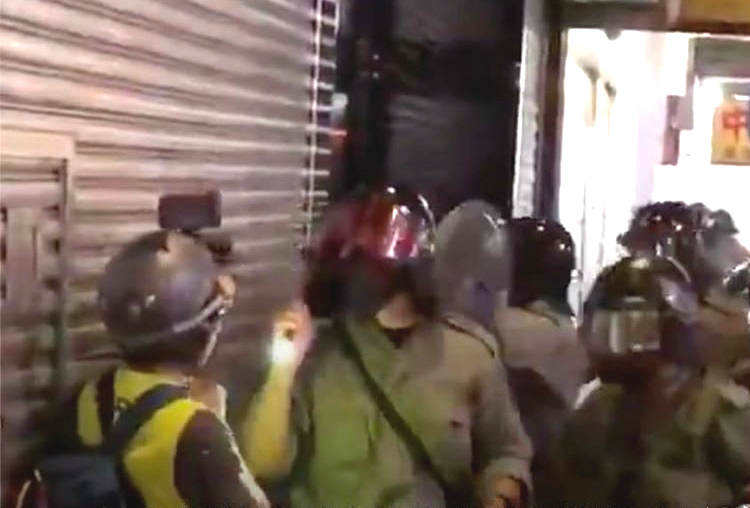 記者在昨日採訪時被防暴警員扯下面罩。港台圖片