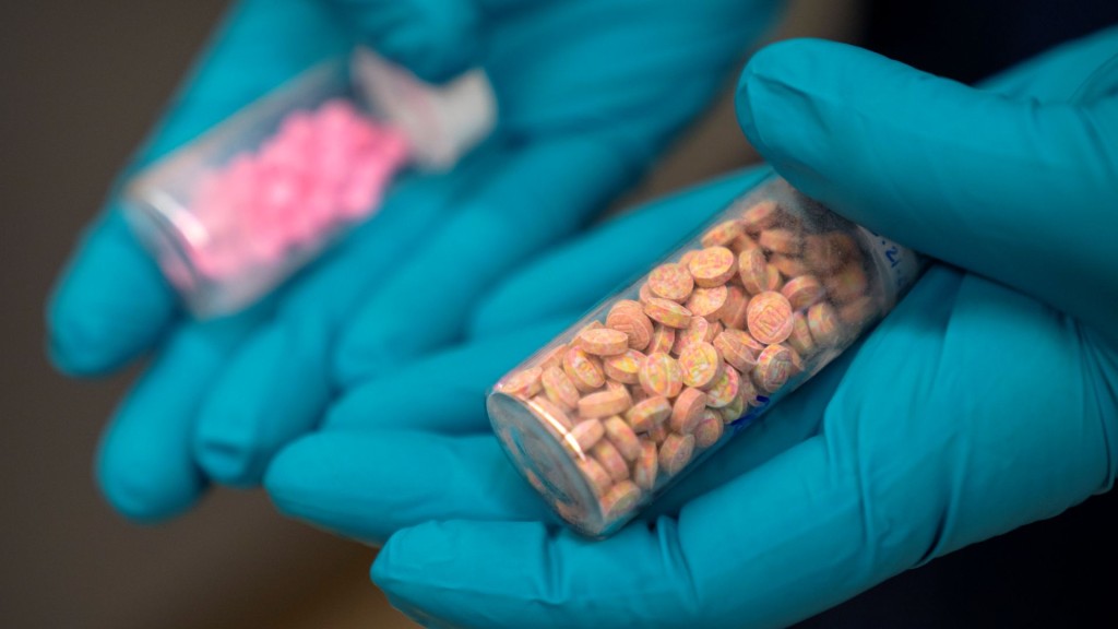 美國緝毒局高級法醫化學家手持芬太尼藥片小瓶。 美聯社示意圖
