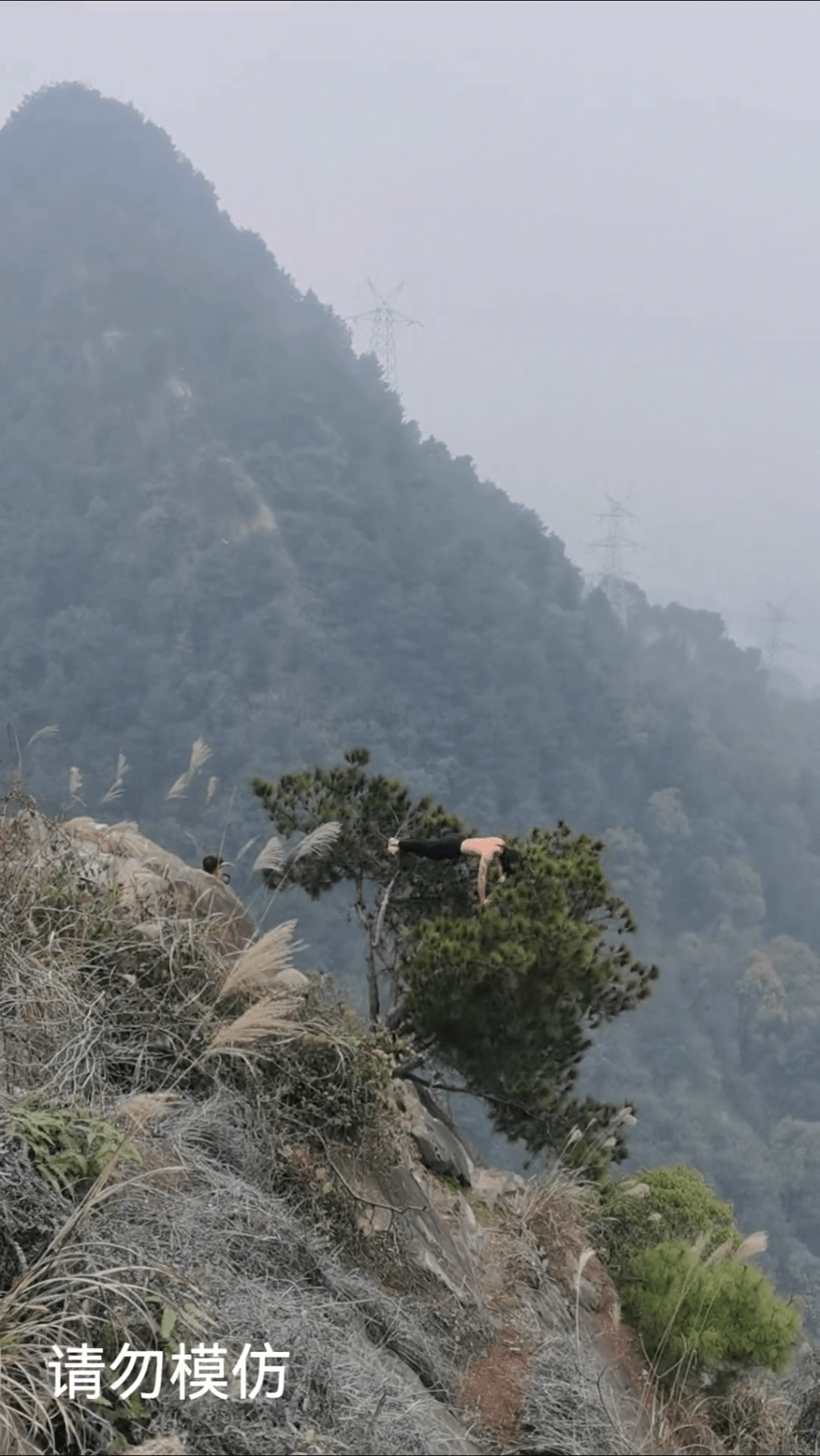 重慶南山虛靈峰，赤膊男子峭壁樹上做「掌上壓」。