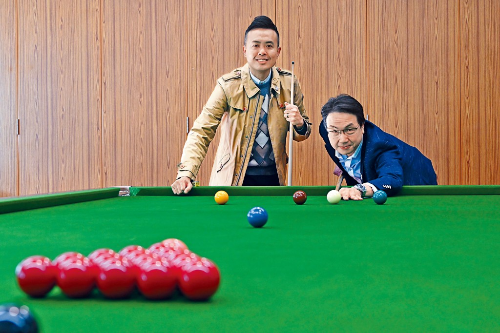 香港桌球手傅家俊（左）近年積極推廣桌球運動，並率先在母校高主教書院，為中學生設計桌球課程。右為高主教書院校長楊世德。