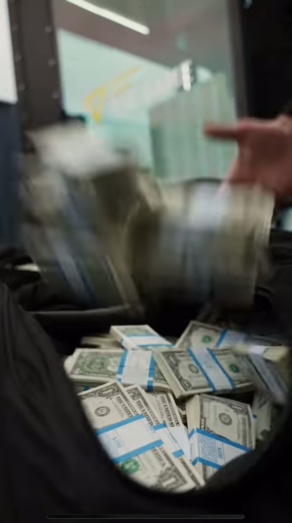 工作人員將美元紙鈔裝入袋。 Youtube