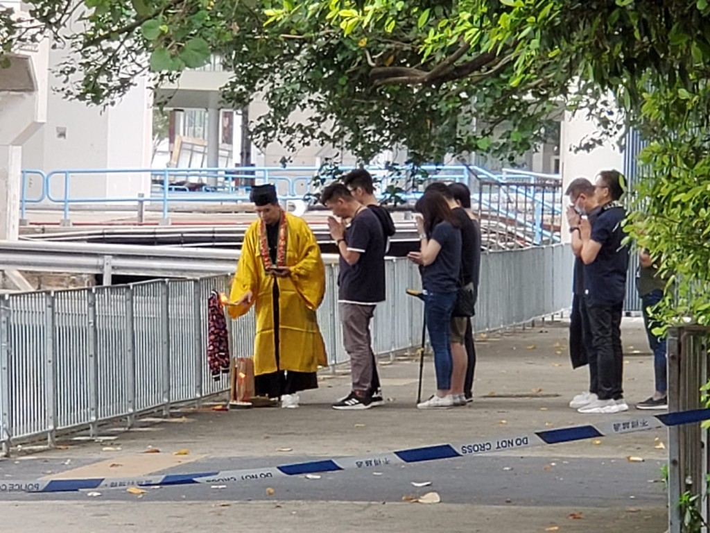 女事主親友一行近10人在觀塘碼頭海邊做法事。