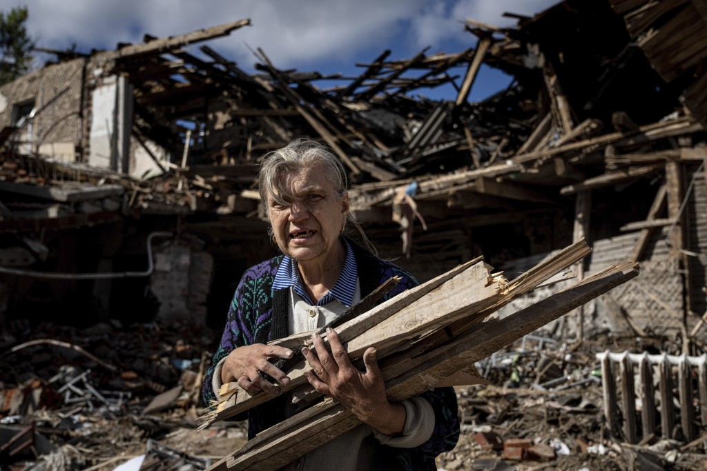 一名婦女從俄羅斯軍隊駐紮在烏克蘭伊齊烏姆地區被摧毀的學校收集取暖用的木材。AP