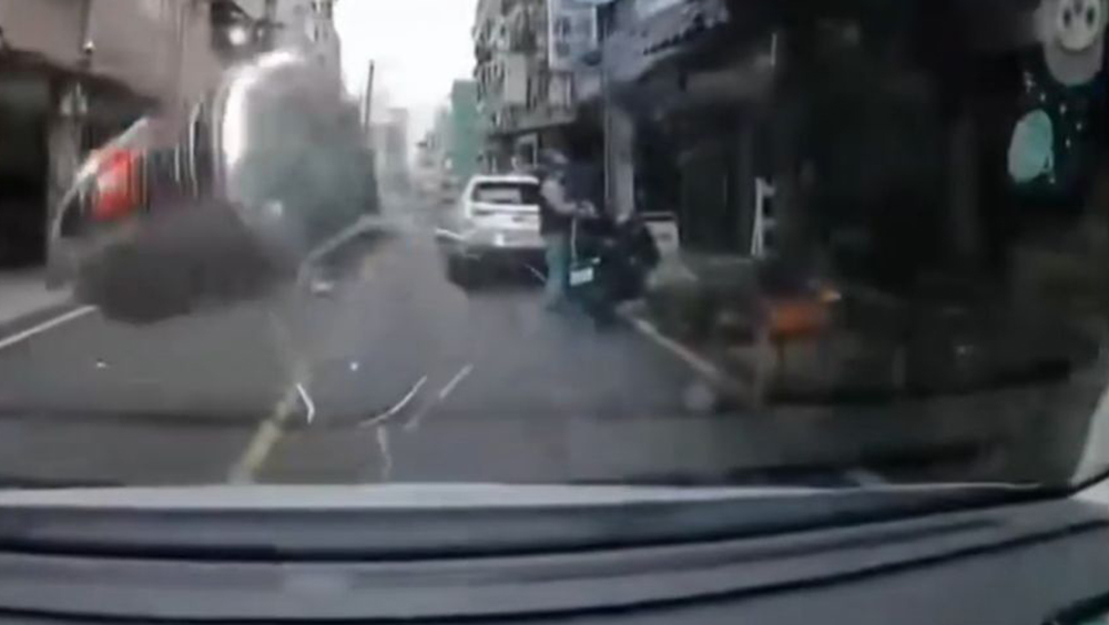 水塔砸中汽车后，弹到马路上。