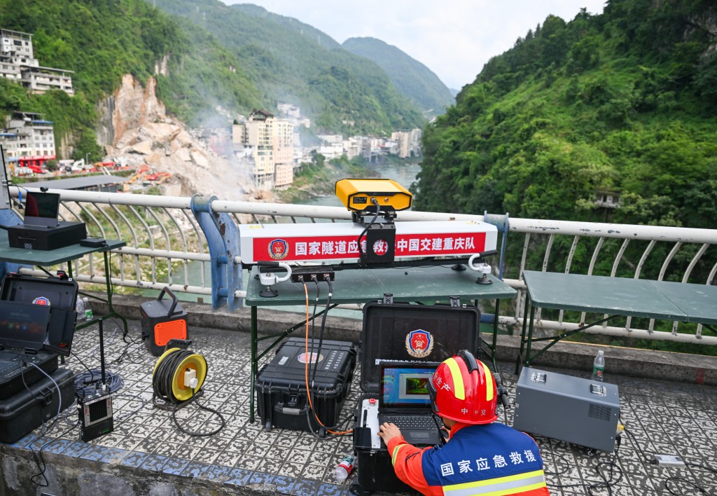 7月17日，救援人员在进行山体稳定性监测。 新华社