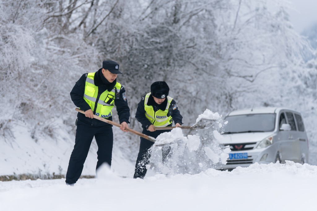 交警抢通被暴雪封阻的公路。