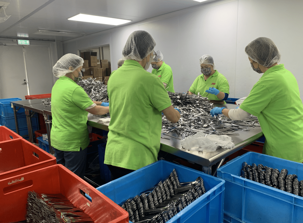 訪問當天記者走進東涌一個工場中，機器運轉聲不絕於耳，員工經消毒後，有些站立剔除殘次品，有些在流水線上分裝紙巾與刀叉，正是國泰與陽光社企合作十多年來每日上演的場景。
