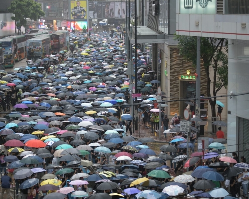 大批示威者撐起傘冒雨遊行。