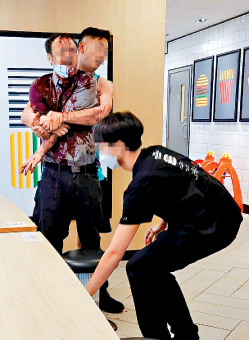男經理案發當日遇襲後血流披面，一名男子從後緊抱着他圖令他冷靜下來。