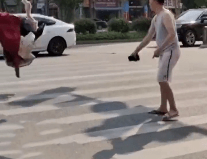 網傳影片顯示，一名男子將一堆衣物拋向馬路中心。