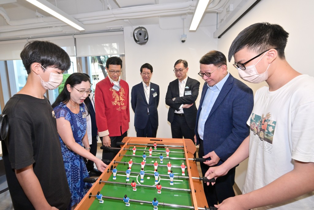 陳國基（右二）和劉焱（左二）在多功能活動區與受惠人士玩足球機，並與他們交流。