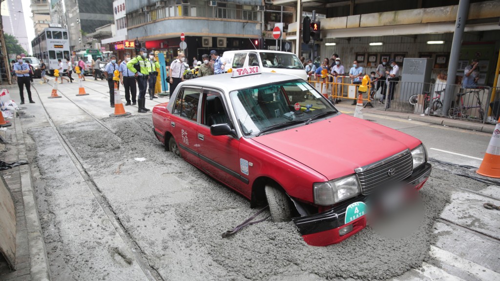 的士誤闖修路工地，車底陷入水泥中。