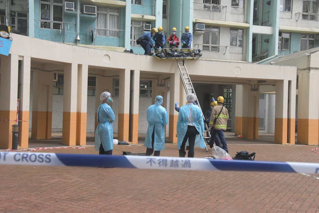 消防員將死者遺體移到地面。