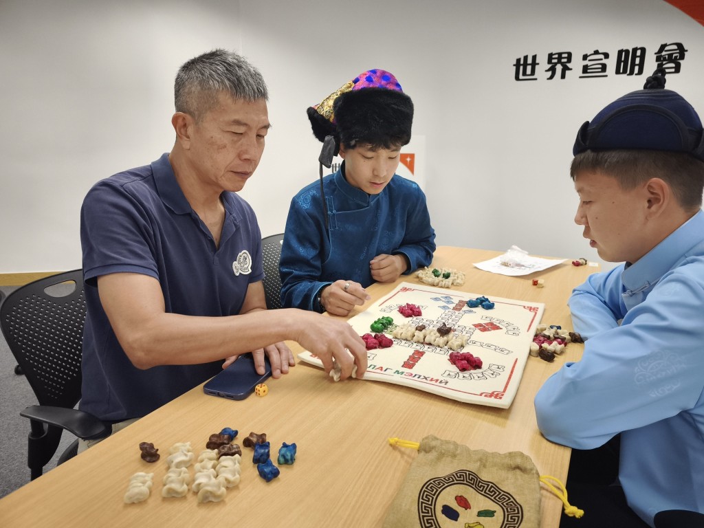 張力耘(左)與Telmen(中)一起玩骨棋。 張力耘(左)與Telmen(中)一起玩骨棋。