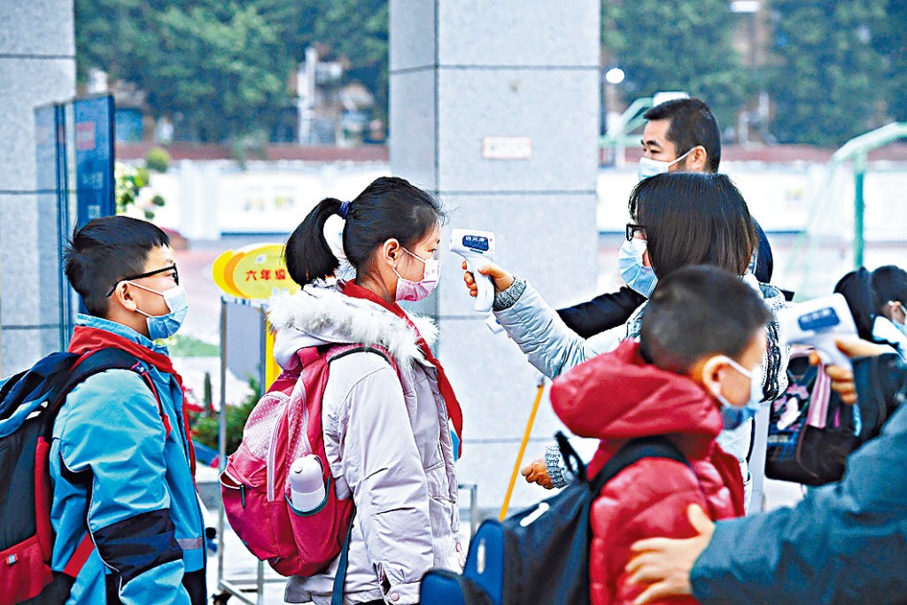 寒假後,學生們戴着口罩進入校園。