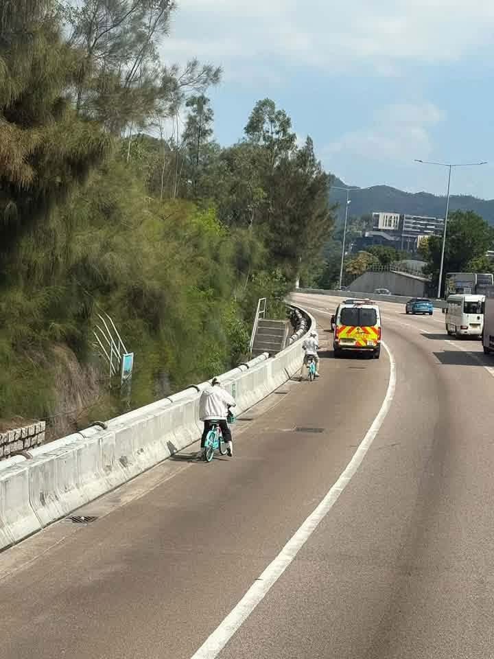 二人沿屯門公路往九龍方向的路肩前行,而前方則有一輛警車。網上圖片 二人沿屯門公路往九龍方向的路肩前行,而前方則有一輛警車。網上圖片