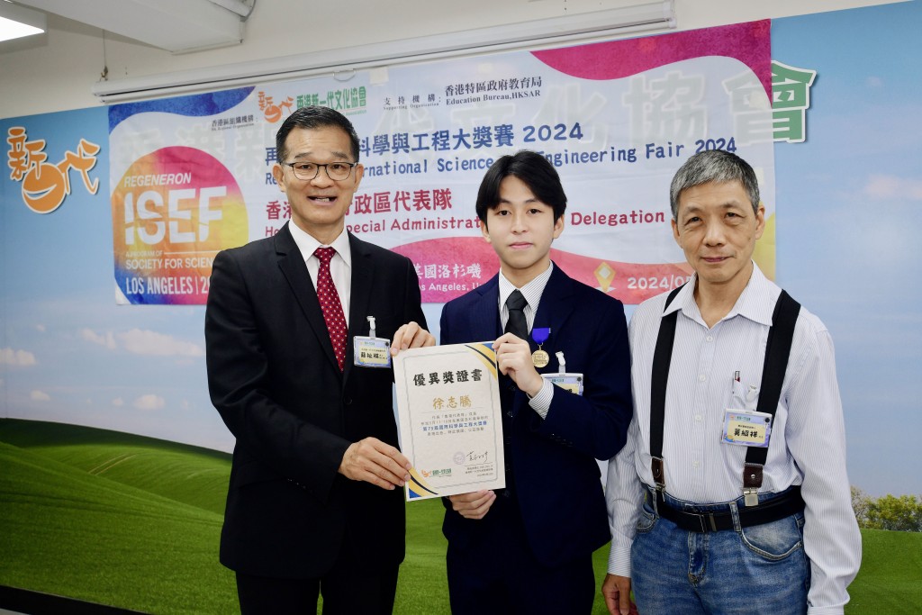 香港新一代文化协会总干事苏祉祺（左）昨向就读中华传道会安柱中学的徐志腾（中）颁发优异奖证书。