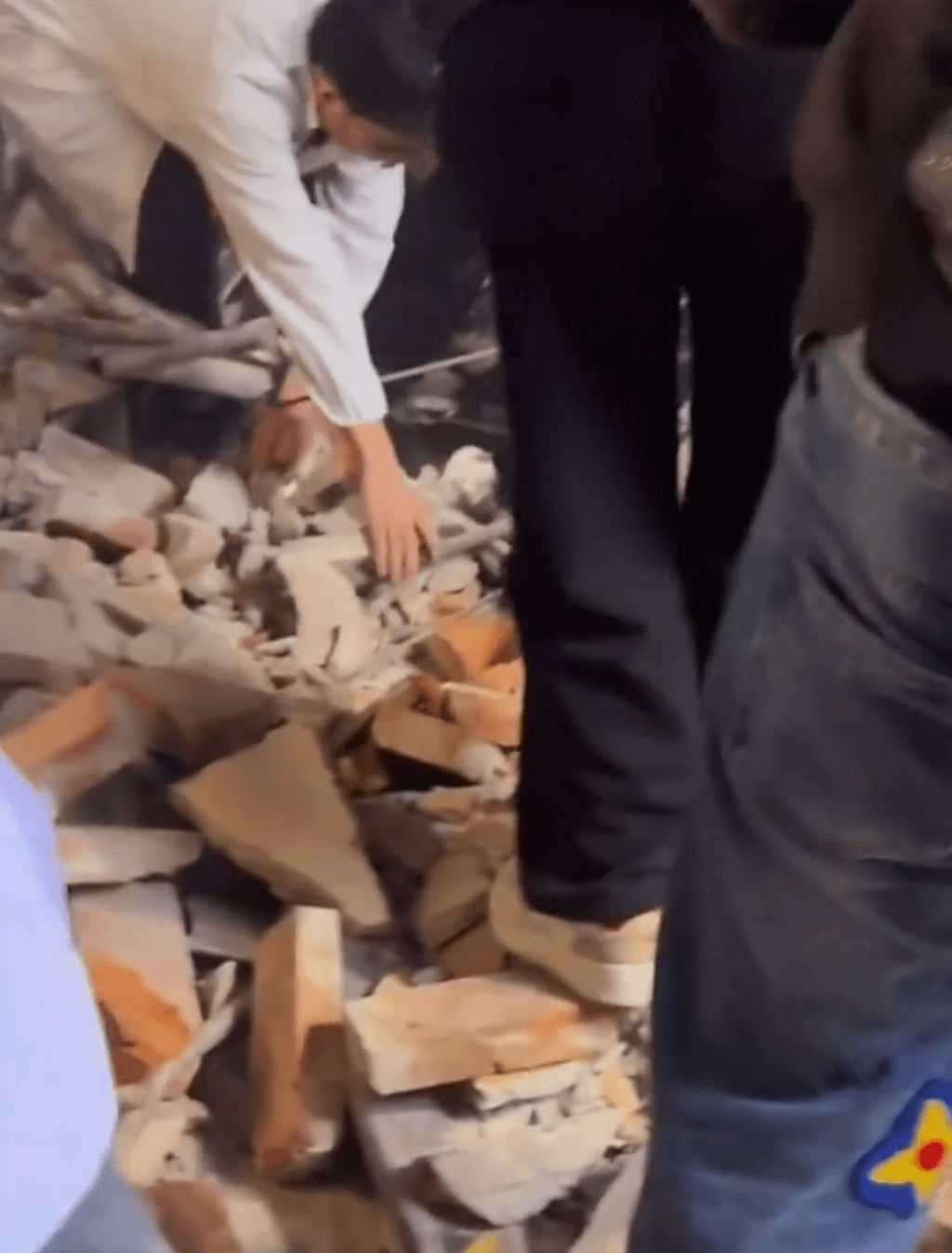 市民合力移開磚瓦將傷者救出。 市民合力移開磚瓦將傷者救出。