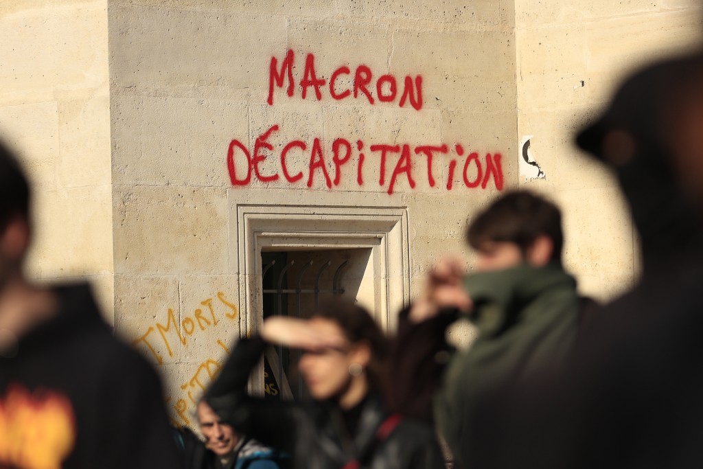 巴黎5.1示威遊行中，有人在牆上塗鴉上寫著「馬克龍斬首」。AP