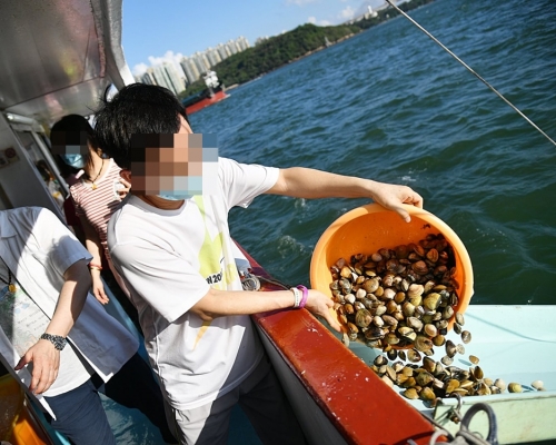 善信輪流將大量不同的種類的生物，包括魚、蜆、鰻魚，「放生」落海。 香港護生群FB圖