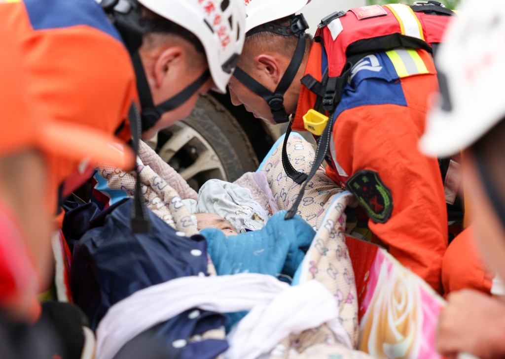 8月6日，吉林市消防救援支队队员将曲凤霞移送至安全地带。新华社