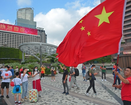 有人在海傍附近揮舞大型國旗。
