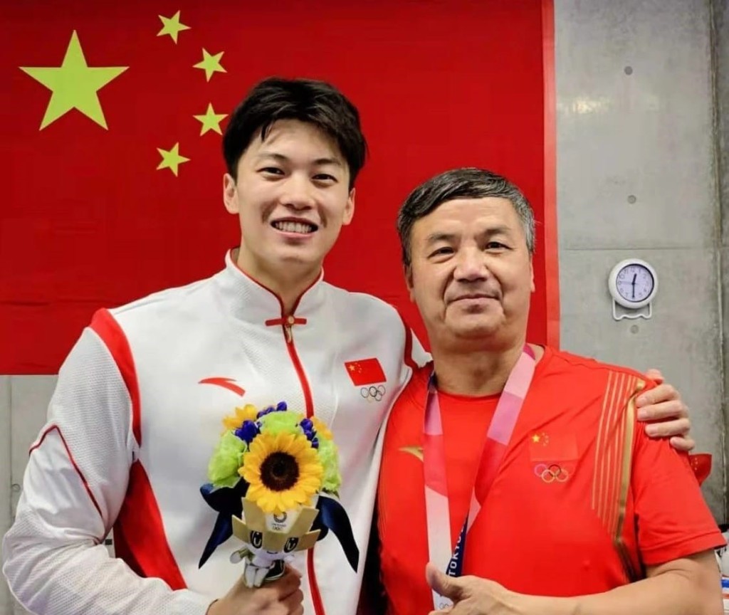 東京奧運會奪冠後，汪順將金牌掛在教練條頸。