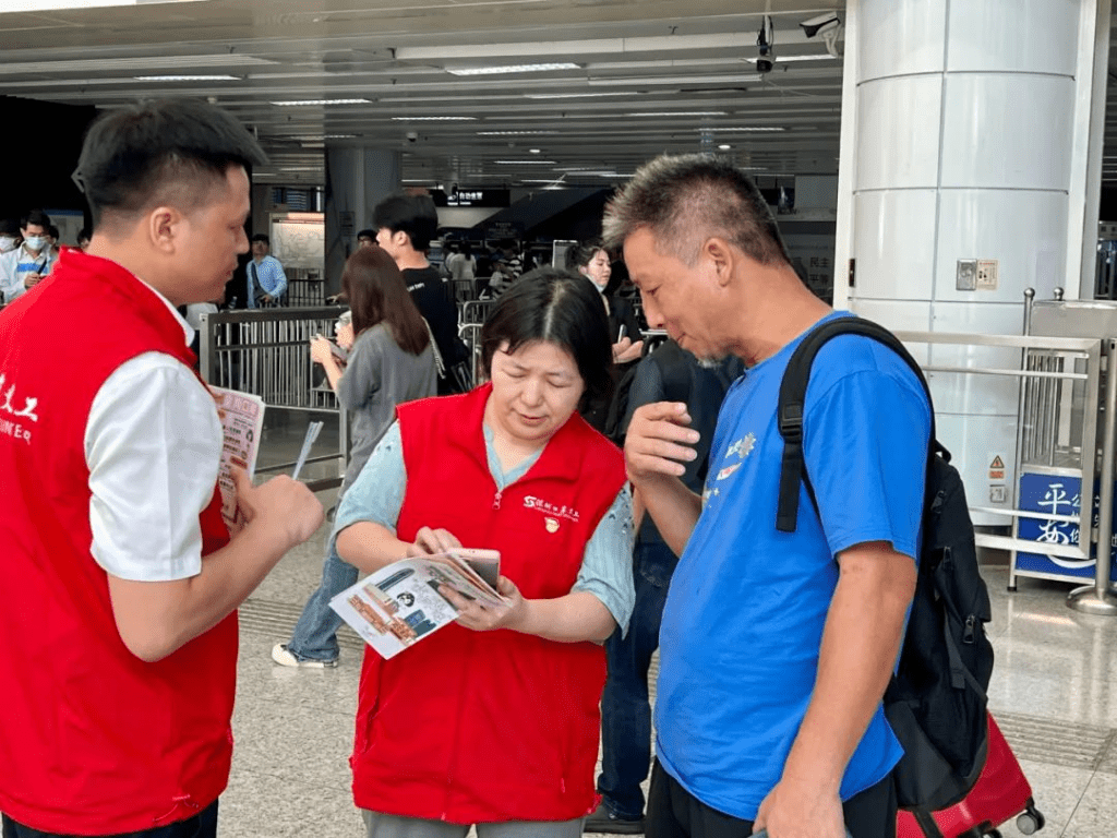 有義工向旅客派發深圳旅遊攻略小冊子，還細心講解。