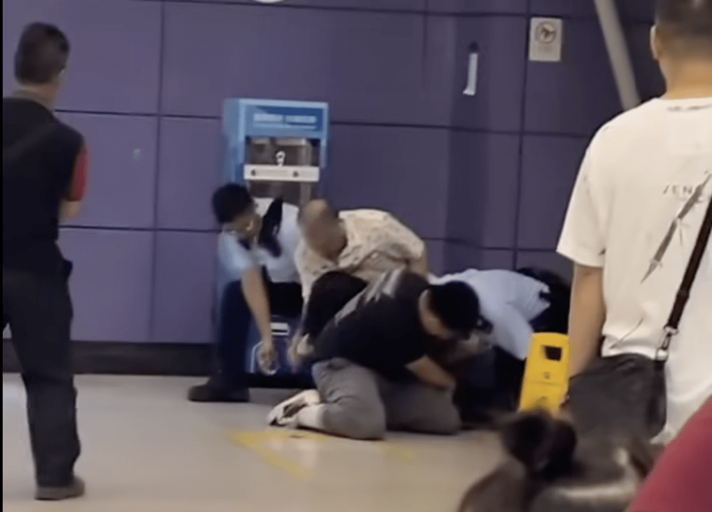 警員嘗試以手銬鎖上疑犯。網上片段截圖 警員嘗試以手銬鎖上疑犯。網上片段截圖