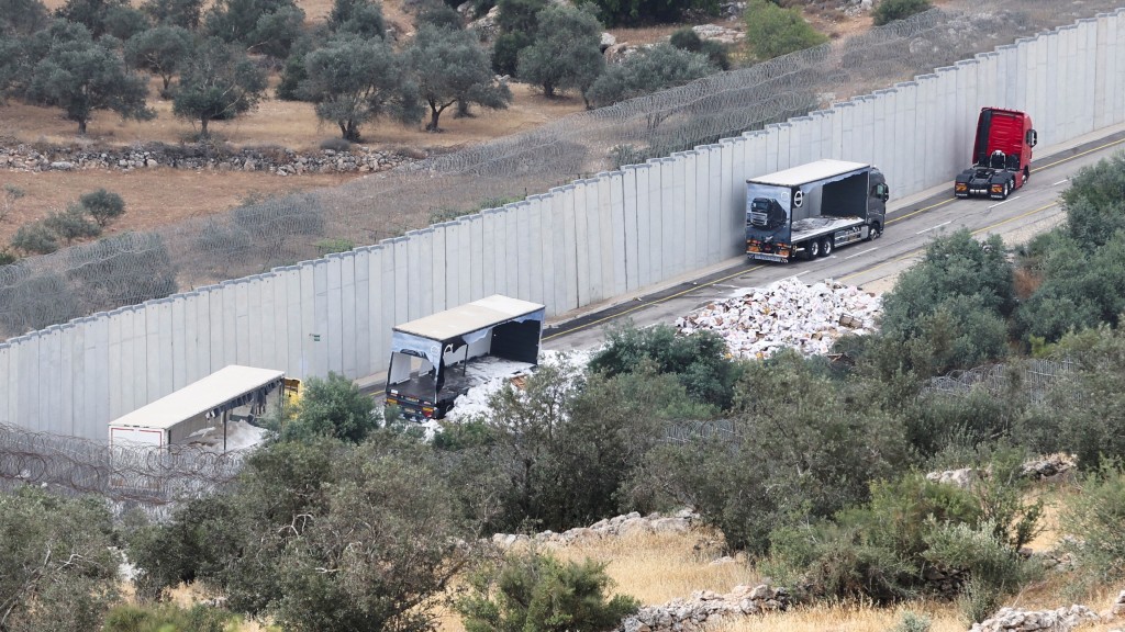 在約旦河西岸希伯侖附近，運送物資的貨車遭被以色列定居者攔截破壞後停在路邊。 路透社