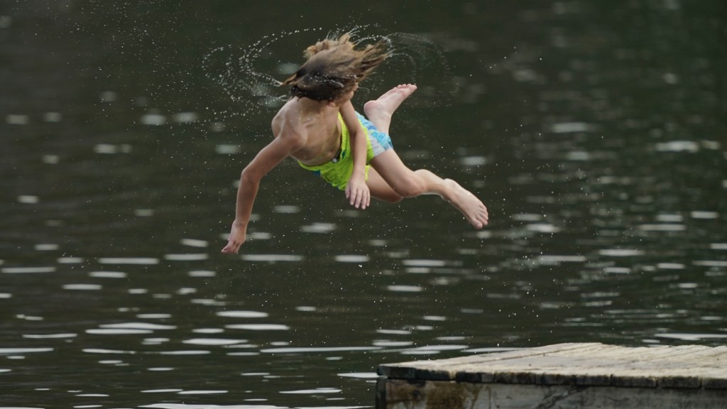 密西西比州蘭金縣居民想盡辦法消暑，有人旋轉跳水入湖。 美聯社