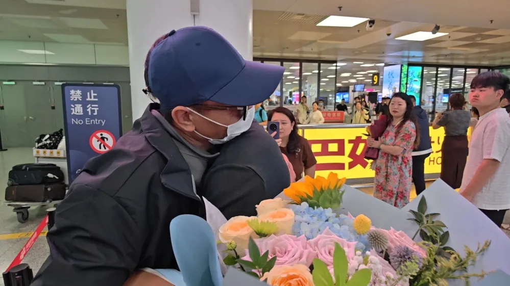 陆海涛与迎接他的儿子陆晨菲紧紧相拥。