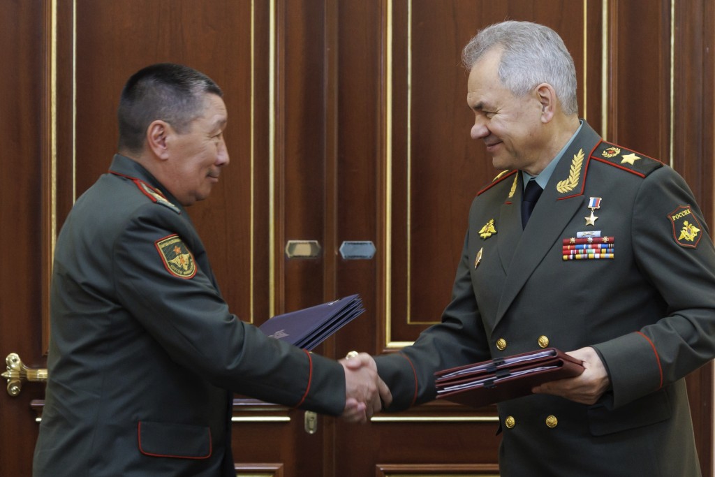 俄羅斯國防部長紹伊古（右）和吉爾吉斯斯坦國防部長貝克博洛托夫握手。 AP