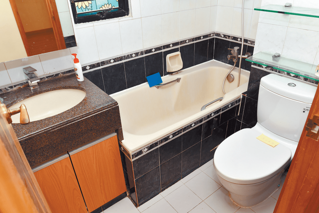 浴室保养得宜，墙上与浴缸旁的黑色瓷砖便于日常打理。