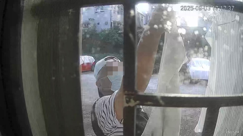 一名身穿間條上衣的男子偷走掛在屋外的一件衫及一條褲。FB「錦上路之友」片段截圖 一名身穿間條上衣的男子偷走掛在屋外的一件衫及一條褲。FB「錦上路之友」片段截圖