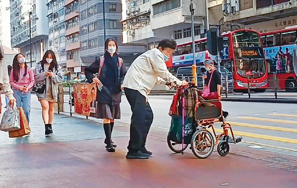 乞兒收工自行站起身，推着輪椅離去。
