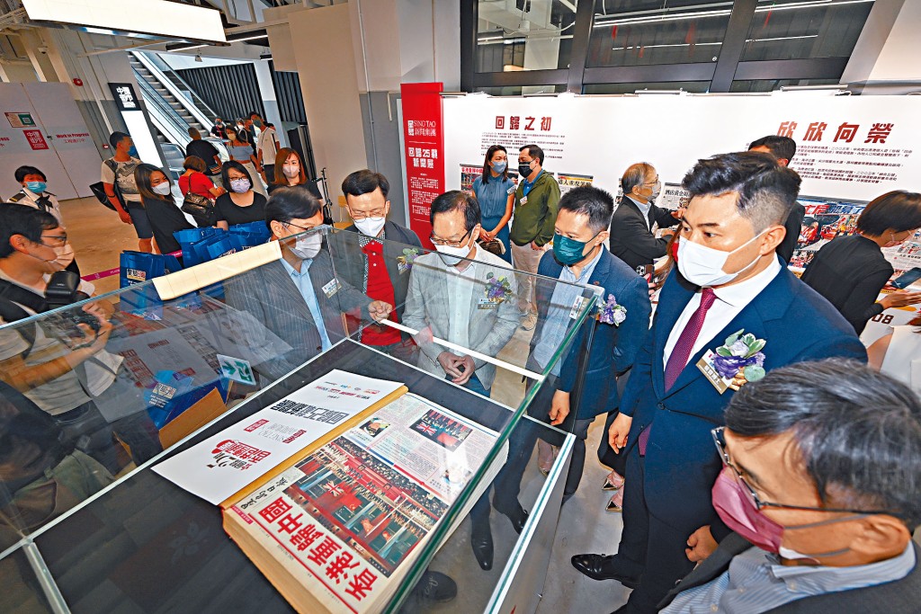 發展局副局長廖振新(右五)及市建局行政總監韋志成(右四),昨在集團執行董事兼聯席行政總裁蔡晋(右二)陪同下,參觀《香港重歸中國》的舊報章。