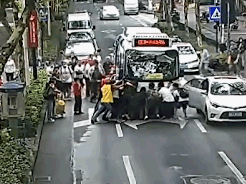 途人一呼百應合力將公車抬起。網圖