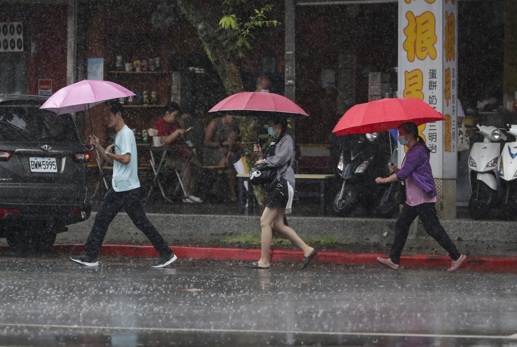 颱風格美逼近台灣台北時，人們在雨中行走。 美聯社