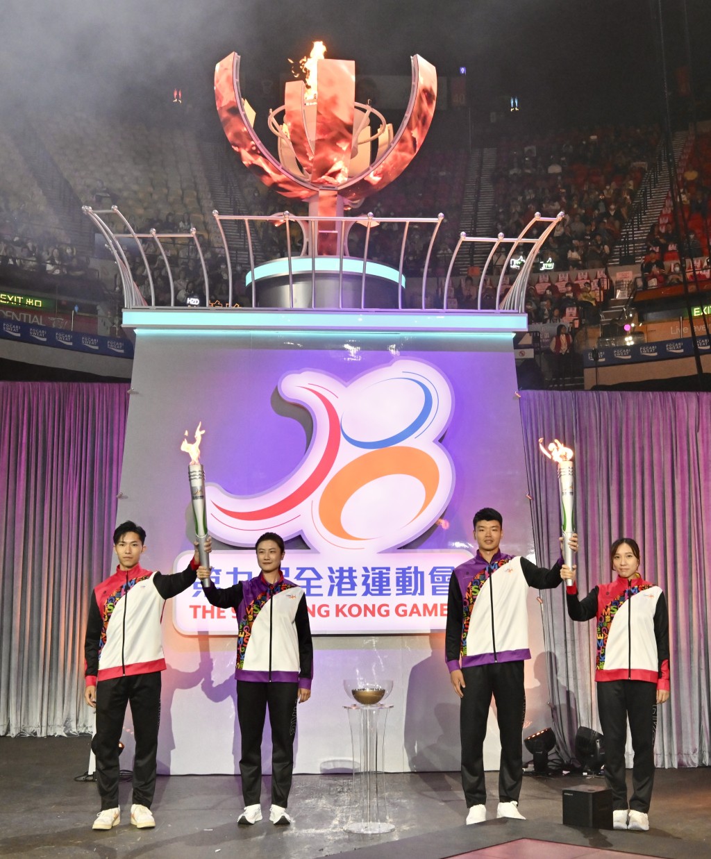 國家奧運金牌運動員丁寧（左二）和王懿律（右二）與香港獎牌運動員許得恩（左一）和蘇慧音（右一）在全港運動會開幕典禮燃點聖火。