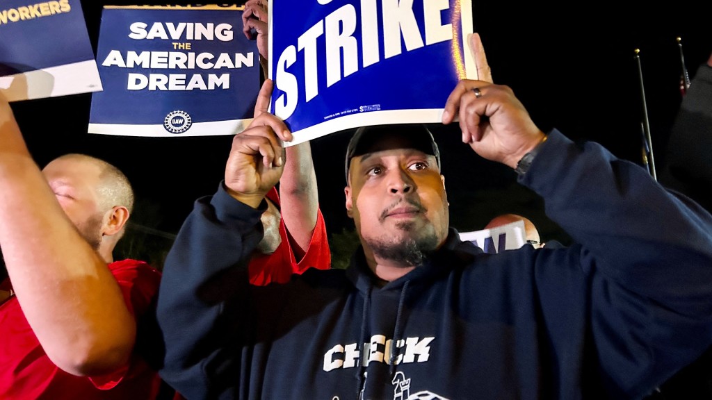 美国三大车企工人罢工，福特韦恩车厂一名工人高举标语牌。路透社