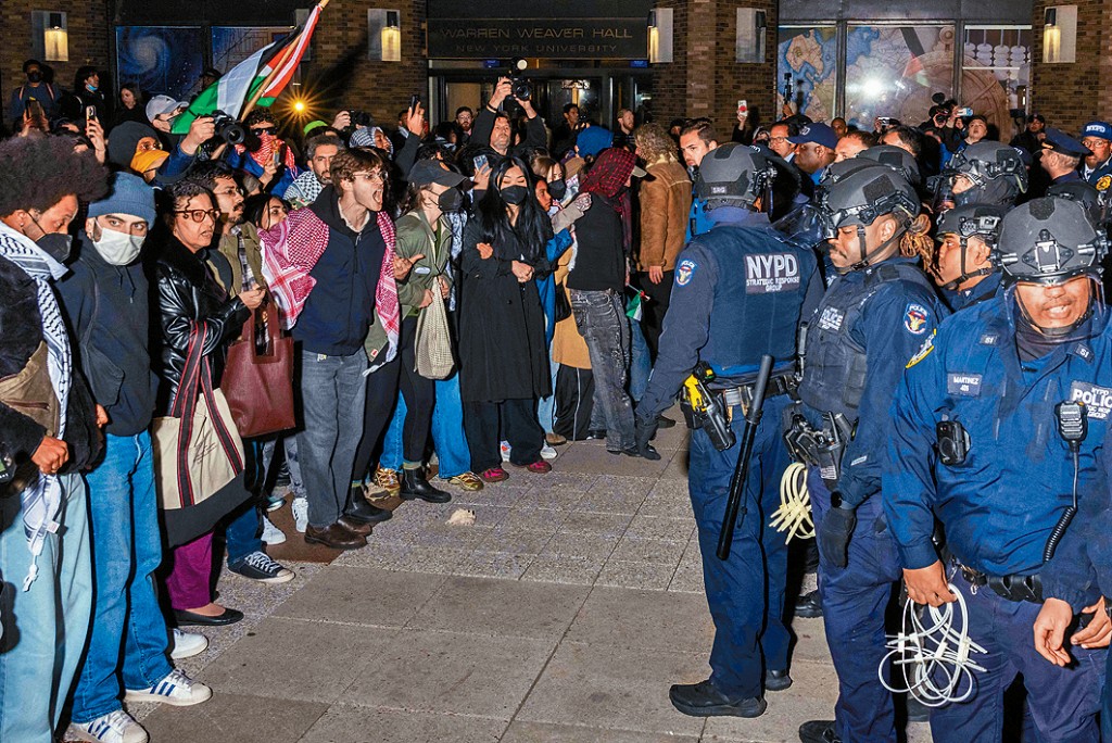 警察在紐約大學拘捕示威者後，與另一群示威者對峙。 
